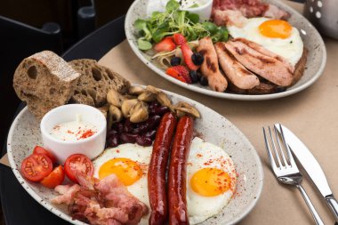 Ev yapımı lezzetli amerikan kahvaltısı. Yanında kızarmış yumurta, tost, sosis, meyve, çilek reçeli, kruvasan.
