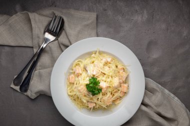 Geleneksel İtalyan makarnası. Somonlu spagetti, masada krem peynir. Akşam yemeği için ahşap masada ev yapımı İtalyan geleneksel makarnası. İtalyan mutfağı..