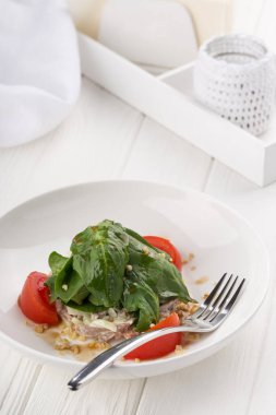 Dana etli salata, domates, biber, beyaz ahşap arka planda ıspanak. Restoran yemeği. Sebzeli et salatası. Salatayı sıcak dana etiyle kapatın. Metin için boşluk