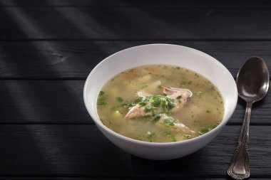 Bir kase tavuk çorbası ve ekmek. Siyah ahşap bir masada beyaz tabakta tavuk çorbası. Tavuklu erişte. Bakso, erişteli köfte çorbası. Metin için boş alan. 