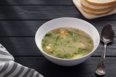 Bir kase tavuk çorbası ve ekmek. Siyah ahşap bir masada beyaz tabakta tavuk çorbası. Tavuklu erişte. Bakso, erişteli köfte çorbası. Metin için boş alan. 