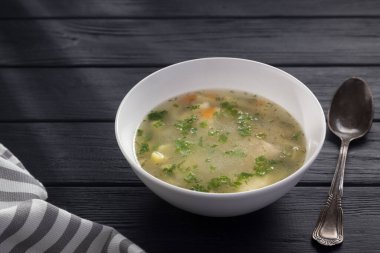 Bir kase tavuk çorbası ve ekmek. Siyah ahşap bir masada beyaz tabakta tavuk çorbası. Tavuklu erişte. Bakso, erişteli köfte çorbası. Metin için boş alan. 