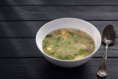 Bir kase tavuk çorbası ve ekmek. Siyah ahşap bir masada beyaz tabakta tavuk çorbası. Tavuklu erişte. Bakso, erişteli köfte çorbası. Metin için boş alan. 