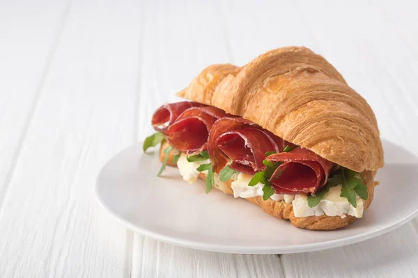 Čerstvý Croissant Šunkou Sýrem Rukolou Bílém Dřevěném Stole Croissant Breakfast — Stock fotografie