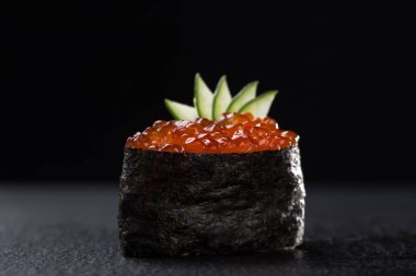 Karanlık bir arka planda havyarlı Gunkanlar. Gunkan suşisini koyu taştan arka planda havyarla yakından izle. Taze Japon mutfağı. Asya yemeği. Menü için suşi resmi. Kırmızı havyarlı suşi.. 