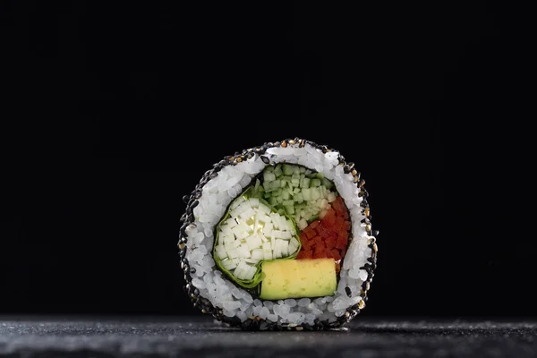 Sushi Rolls with vegetables on a dark background. Sushi set on a stone plate and dark concrete background. Sushi roll set and chopsticks. Fresh Japanese cuisine. asian food. Sushi image for menu. close up