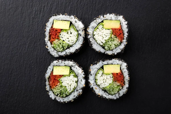 Sushi Rolls with vegetables on a dark background. Sushi set on a stone plate and dark concrete background. Sushi roll set and chopsticks. Fresh Japanese cuisine. asian food. Sushi image for menu. close up