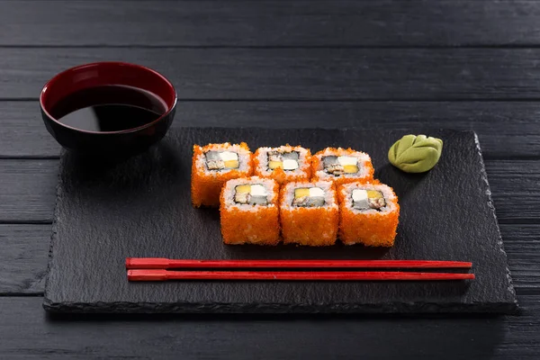 Sushi set. maki, gunkan and sushi rolls served on stone slate. Sushi set on a stone plate and dark concrete background. Sushi roll set and chopsticks. Fresh Japanese cuisine. asian food. Sushi image for menu. close up