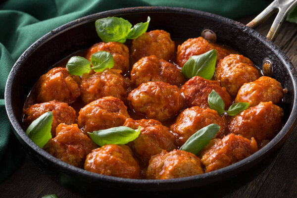 Traditional italian Meatballs served on a old wooden table. Meatballs served on a old wooden table with green napkin and spoon. Homemade delicious italian Meatballs on on a rustic table for dinner. italian cuisine.