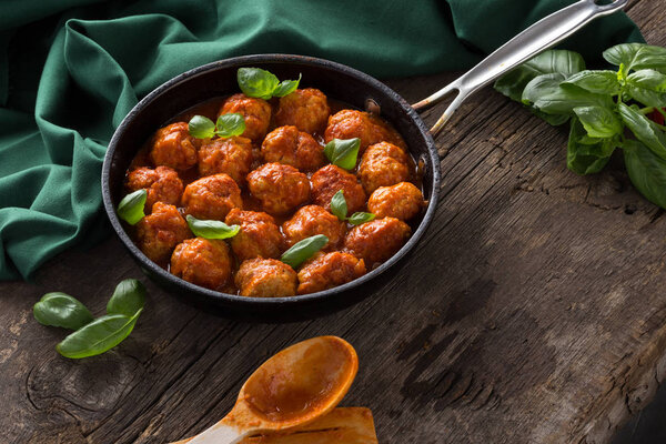 Traditional italian Meatballs served on a old wooden table. Meatballs served on a old wooden table with green napkin and spoon. Homemade delicious italian Meatballs on on a rustic table for dinner. italian cuisine.