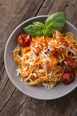 Geleneksel İtalyan makarnası eski ahşap bir masada servis edilir. Köfteli makarna, parmesan peyniri ve otlar. Ev yapımı lezzetli İtalyan geleneksel makarnası kırsal bir masada akşam yemeği için. İtalyan mutfağı..