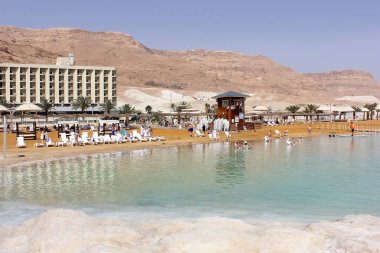Dead Sea, Ein Bokek, İsrail - 18 Mart: tatilcilerin ve turistler Ölüdeniz lüks oteller arka plan üzerinde 18 Mart 2018 yıkayın