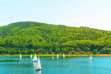 Dağların fon karşı yelkenli yat