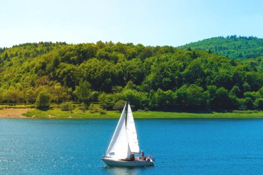 Dağların fon karşı yelkenli yat