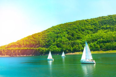 Dağların fon karşı yelkenli yat