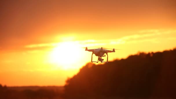 Quadcopter in lucht tijdens zonsondergang. — Stockvideo