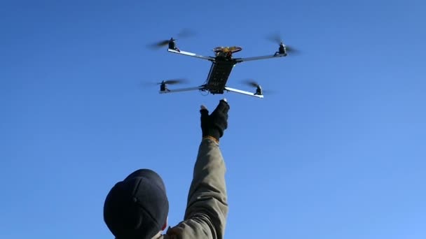 Adam mavi gökyüzünde el yapımı quadcopter yakalamak. Ağır çekim. — Stok video
