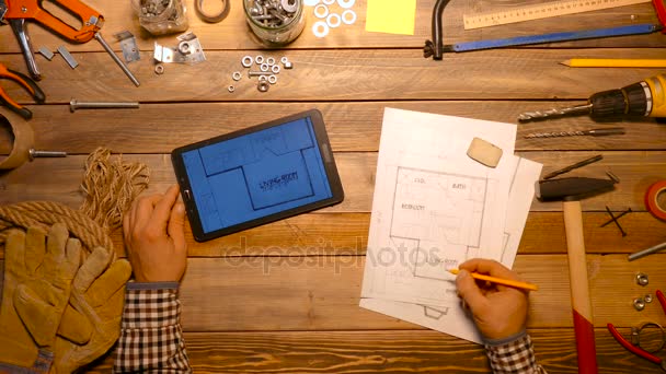 Řemeslník pracující s výkresy a digitální tablet. Pohled shora. — Stock video