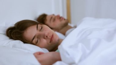 Çift yatakta kayma. Genç kadın üzerinde odaklanmak.