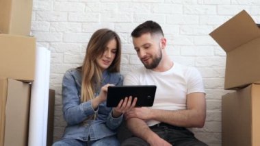 İnterieur planlama, dijital tablet kullanarak yeni evde mutlu çift.