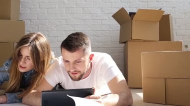 Mutlu çift dijital tablet ve çizim (plan) onlar ile yeni ev. Yer değiştirme. Kaymak vurdu.