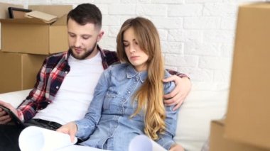 Çift kanepede oturan ve çizim yeni evlerinin tartışıyor.