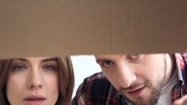 段ボール箱を開き それを見て幸せなカップル — ストック動画