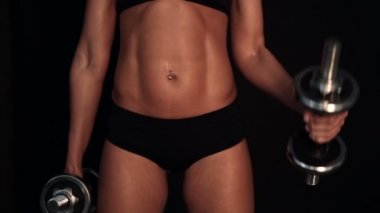 Fitness kadın iki dumbbells ile pazı egzersiz yapmak. Siyah arka plan. Yakın çekim.