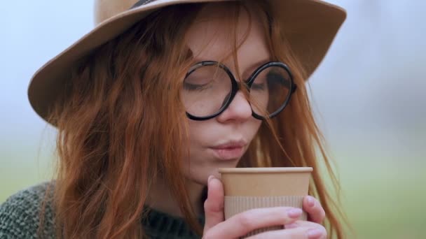 Κοντινό Πορτραίτο Της Νεαρής Κοκκινομάλλας Γυαλιά Πίνει Καφέ Έξω Επιβράδυνση — Αρχείο Βίντεο