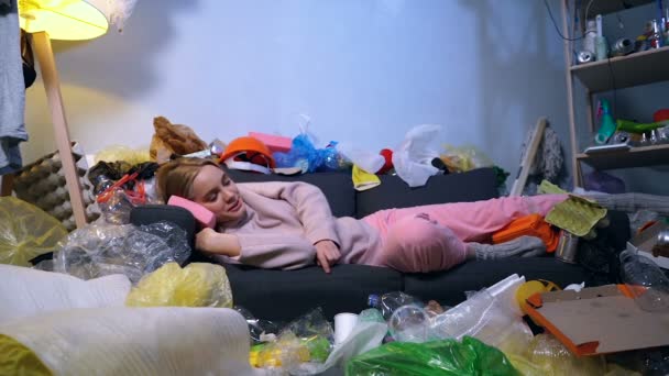 Ung Blond Kvinna Sover Soffan Rummet Full Skräp Och Skräp — Stockvideo