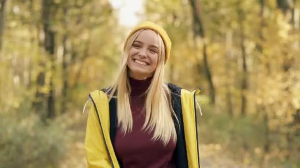迷人的 微笑的 快乐的金发女子在秋天的森林里散步 手持射击 — 图库视频影像
