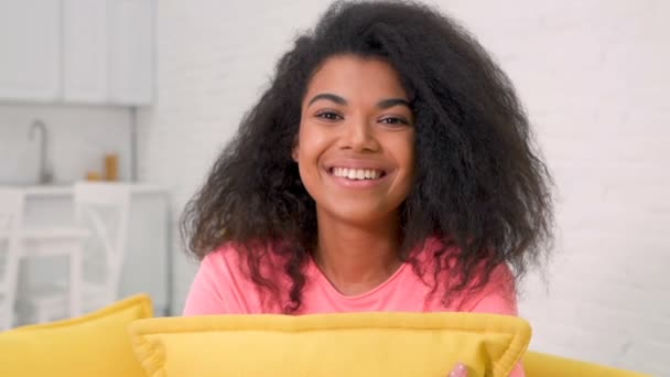 Bonita Aconchegante Jovem Afro Americana Sentada Sofá Abraçando Almofada Olhando — Vídeo de Stock