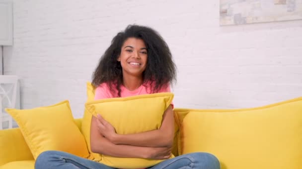 Smiling Afro American Woman Sitting Yellow Sofa Hugging Pillow Smiling — 图库视频影像