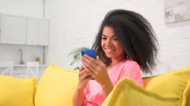 Koltukta cep telefonuyla oturan genç bir kadının portresi. El kamerasıyla..