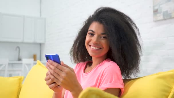 Portret Szczęśliwej Młodej Kobiety Siedzącej Kanapie Trzymającej Telefon Komórkowy — Wideo stockowe