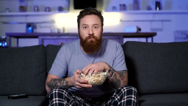Homem Barbudo Sentado Sofá Comer Pipocas Ver Televisão Movimento Lento — Vídeo de Stock