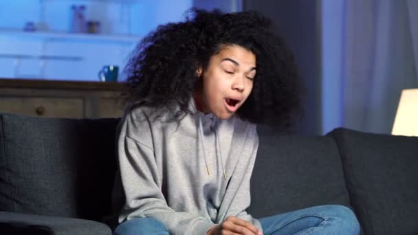 興奮アフロアメリカ人女性食べるポップコーンと見るテレビにホーム — ストック動画