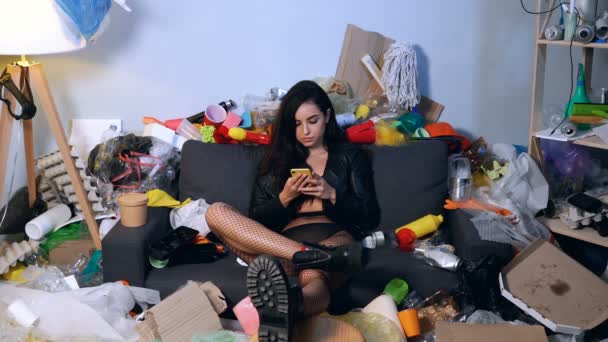 Młoda Biała Kobieta Siedząca Pokoju Śmieciami Śmieciami Trzymanie Smartfona Pisanie — Wideo stockowe