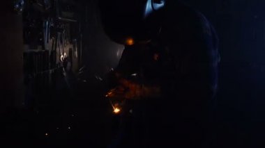Kasklı kaynakçı metalle çalışıyor. El bilgisayarı atışı.