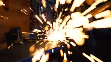 Dairesel öğütücü kullanan metal işçisi. Kameraya doğru uçan kıvılcımlar.