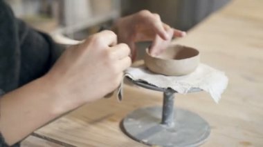 Kadın elinin tabaktan seramik kupa oluşturduğu görüntüleri kapatın. El kamerasıyla..
