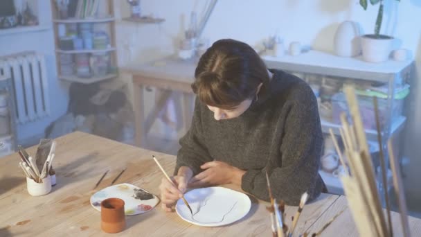 Künstlerin Die Der Kunstwerkstatt Mit Keramikteller Arbeitet Pinsel Und Malerei — Stockvideo