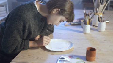 El işi seramik tabakta resim yapan kadın. El kamerasıyla..