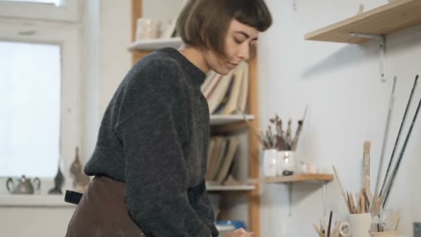 年轻的女艺术家正在准备一块粘土 并将其混合在工作台上 慢动作 — 图库视频影像