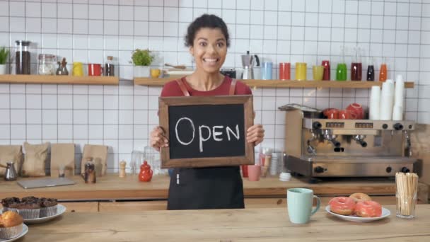 Neşeli Kafeterya Çalışanı Elinde Üzerinde Açık Yazan Bir Balkon Tutuyor — Stok video