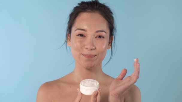 Close Portrait Pretty Looking Asian Woman Applying Cream Nose Blue — Stock Video