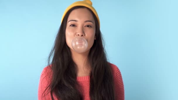 Retrato Bonito Asiático Mulher Soprando Chiclete Fundo Azul Movimento Lento — Vídeo de Stock