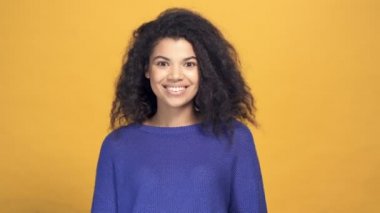 Afro-Amerikan bir kadının sessizlik işareti gösteren portresini yakından çek. Sarı arkaplan.