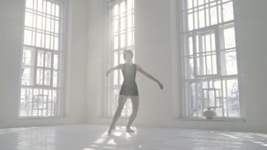 Bale stüdyosunda kendi etrafında dönen balerin. Düşük açı.