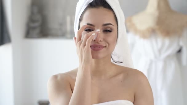 シャワー後の顔にクリームを塗る魅力的な女性のクローズアップポートレート 手持ち撮影 — ストック動画